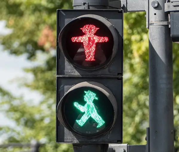 Eine Fußgängerampel, sowohl Grün als auch Rot leuchten.